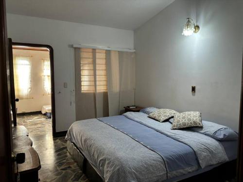 1 dormitorio con 1 cama con 2 almohadas en Lujosa casa, excelente sector, amplia con piscina, en Cúcuta