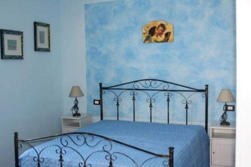 a bedroom with a bed with a blue wall at Bed and Breakfast Don Angelo Miramare in Realmonte