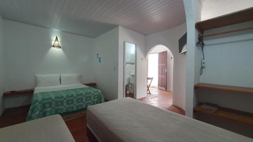 um quarto de hotel com duas camas e um corredor em Pousada Unidos em Jijoca de Jericoacoara