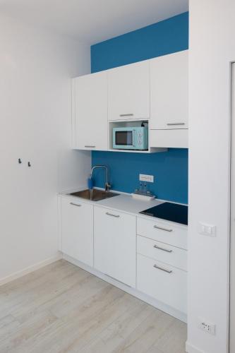 a white kitchen with a sink and a microwave at Cà Cianfer in Bergamo