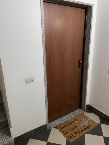 a brown door with a welcome mat on the floor at La Corte del Principe in Bracciano