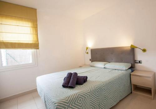 1 dormitorio con 1 cama con 2 toallas en Casa en primera linea en Binibeca Vell en Binibeca