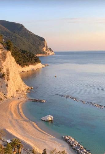 a beach with a large rock in the water at Sottosanta in Numana