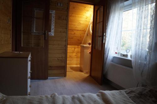 a bedroom with a door leading to a bathroom at Uroczy Dom Całroczny W Bogaczewie Nad Jeziorem Narie in Bogaczewo