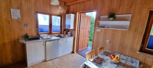 - une cuisine avec un évier et une table dans une chambre dans l'établissement Domki Letniskowe Las Palmas Dąbki, à Dąbki