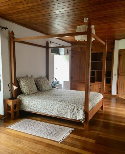 a bedroom with a canopy bed with a wooden ceiling at Casa do Pombal in São Mateus