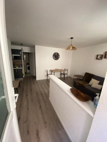 ein Wohnzimmer mit einem Sofa und einem Tisch in der Unterkunft Appartement proche CNPE et PIPA in Saint-Denis-en-Bugey