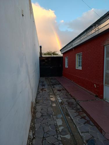 um arco-íris no céu sobre um edifício de tijolos em Casa Catalina zona sur em Comodoro Rivadavia