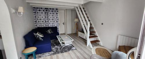 - un salon avec un canapé bleu et un escalier dans l'établissement A 100m de la plage, clim, Aperçu mer, wifi, 2 chambres, 2 salles de bains, 2WC, à Saint-Georges-de-Didonne