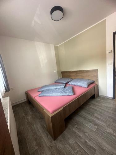 1 dormitorio con 1 cama con sábanas y almohadas rosas en Apartmán Horalka 7 v Peci pod Sněžkou, en Pec pod Sněžkou