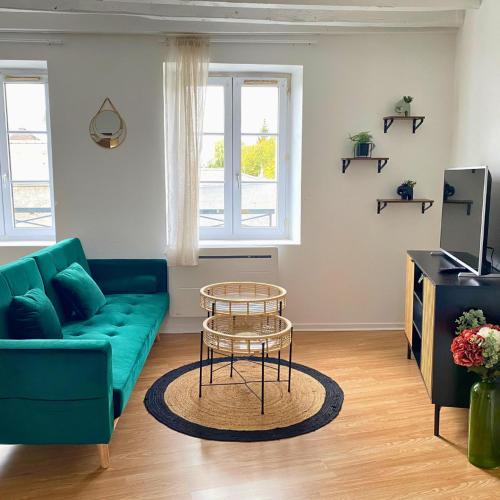 Charmant Studio à Étampes في إتامب: غرفة معيشة مع أريكة زرقاء وطاولة