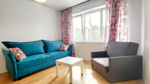 a living room with a blue couch and a chair at APARTAMENTY Charzykowy in Charzykowy
