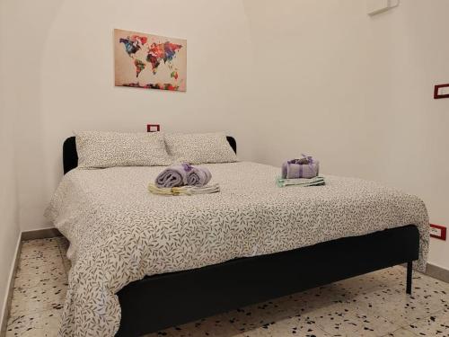 een slaapkamer met een bed met twee handdoeken erop bij House of roses in Ceglie Messapica
