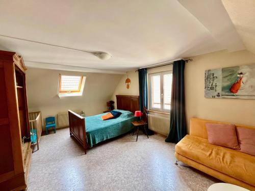 1 dormitorio con 1 cama y 1 sofá en Au jardin de la Maison des Soeurs en Mutzig