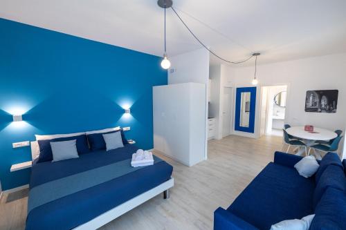 Dormitorio azul con cama y sofá en Cà Cianfer en Bergamo