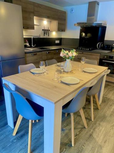 une table de cuisine avec des chaises et un vase de fleurs. dans l'établissement Maison Allemond pour Alpe d'Huez, à Oz