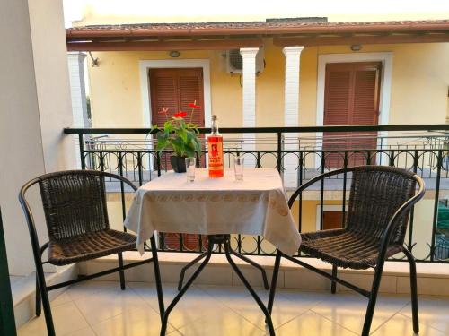 einen Tisch mit einer Flasche Wein auf dem Balkon in der Unterkunft Nikos Apartments 2 in Kavos