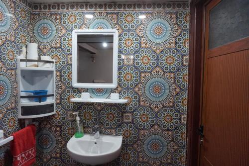 a bathroom with a sink and a mirror on a wall at SamIfrane1 in Zaouia dʼIfrane