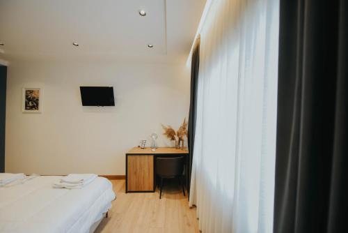 a room with two beds and a desk and a window at Hotel Blini in Shkodër