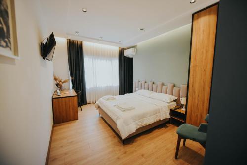 1 dormitorio con cama, escritorio y silla en Hotel Blini, en Shkodër