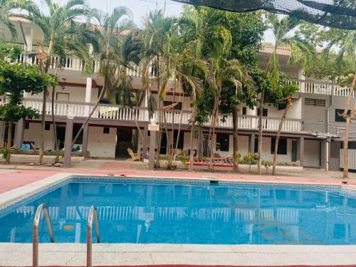 een zwembad tegenover een hotel met palmbomen bij Keona Beach in La Libertad