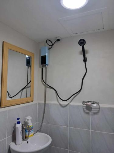 La salle de bains est pourvue d'un sèche-cheveux sur le mur. dans l'établissement New Cozy Studio Apartment, à Marigondon