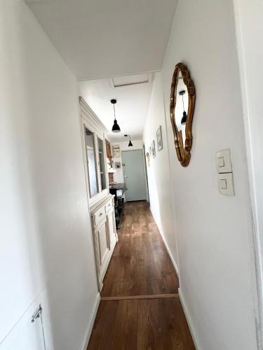 a hallway with white walls and a mirror on a wall at RÉNOVÉ, vue SUR Palais des Papes, terrasse et WIFI TROISIEME ETAGE in Avignon
