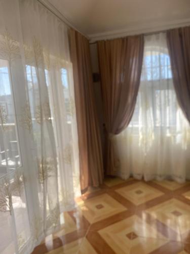 a room with a window with curtains and a wooden floor at Villa à pereybere in Pereybere