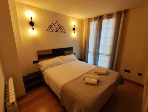 a bedroom with a bed with two towels on it at Dúplex en Valencia d'Àneu (Baqueira Beret) in Valencia de Aneu