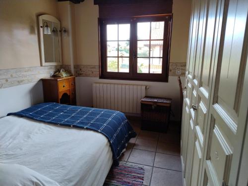 ein kleines Schlafzimmer mit einem Bett und einem Fenster in der Unterkunft Dúplex Somo Beach in Somo