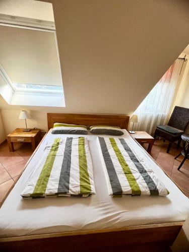 a bed with striped pillows on it in a room at Pension Kolibri in Hemmoor