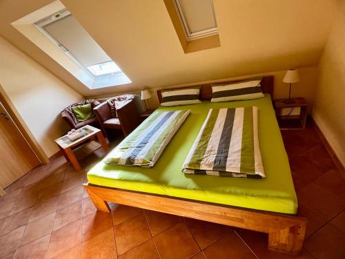 una camera con un grande letto verde di Pension Kolibri a Hemmoor