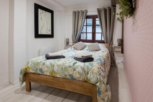 une chambre avec un lit avec des oreillers dessus dans l'établissement Tendr’Escale, honfleur, à Honfleur