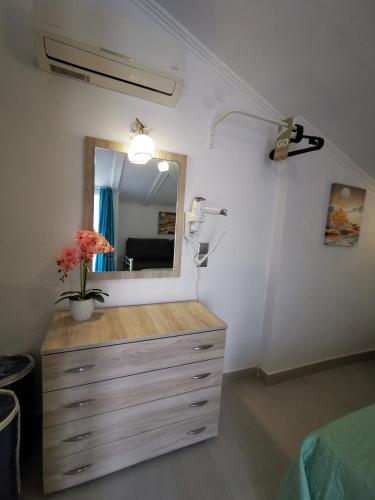 a bedroom with a dresser with a mirror and a fan at Anthis Studios in Pythagoreio