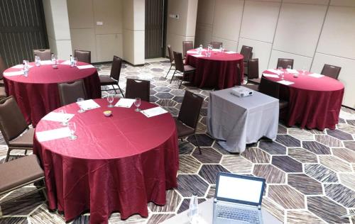 a room with tables and chairs and a laptop at Olive Tree Hotel Penang in Bayan Lepas