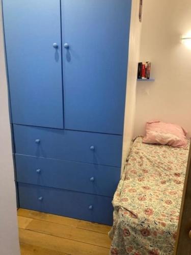 - une commode bleue dans une chambre avec un lit dans l'établissement Charmant 3 pièces idéal JO 2024, à Boulogne-Billancourt