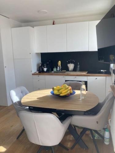 - une table avec un bol de bananes dans la cuisine dans l'établissement Charmant 3 pièces idéal JO 2024, à Boulogne-Billancourt