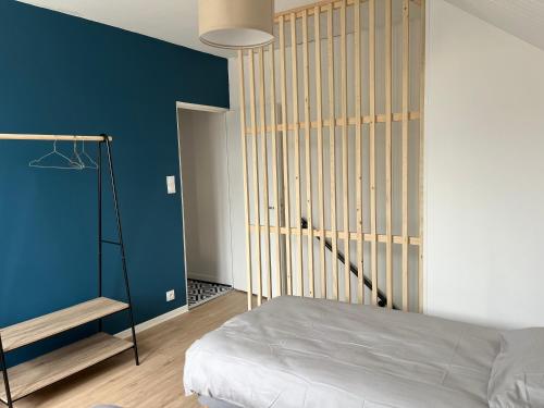 1 dormitorio con cama y pared azul en Gîte T3 cœur de ville, en Sully-sur-Loire