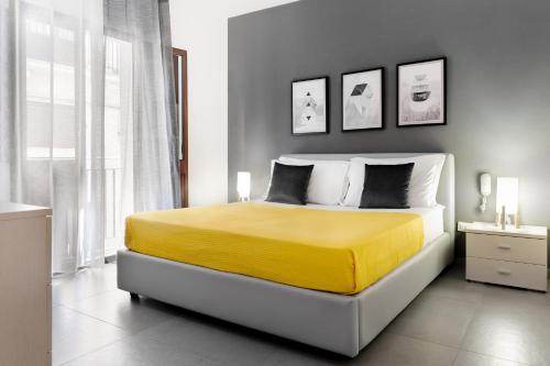 a bedroom with a bed with a yellow blanket at Ciuriddu Appartamenti in Castellammare del Golfo