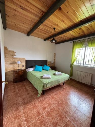 ein Schlafzimmer mit einem Bett in einem Zimmer mit Holzdecken in der Unterkunft Las Mil y Una Rosas in Avila