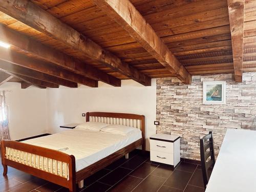 een slaapkamer met een bed en een bakstenen muur bij OA's beach apartment in Vlorë