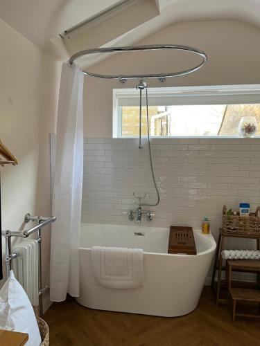 a white bath tub in a bathroom with a window at The chalet in Chandlers Ford