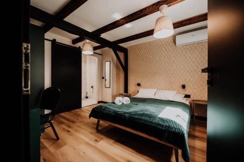 a bedroom with a green bed in a room with wooden floors at Coś miłego in Gowidlino
