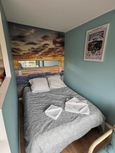 a bedroom with a bed with a painting on the wall at Studio Sunset Biarritz in Biarritz