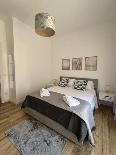 a bedroom with a large bed with two towels on it at ZEFIRO OSTIA-Free parking & Terrace in Lido di Ostia