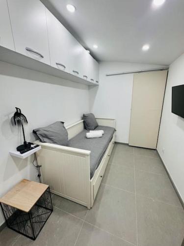 Kleines Zimmer mit einem Bett und einem Tisch in der Unterkunft Studio meublé in Marseille