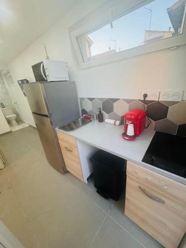 une cuisine avec un réfrigérateur et un plan de travail dans l'établissement Studio meublé, à Marseille