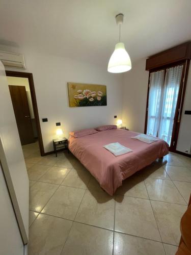 レッジョ・エミリアにあるCasa Linabelliのベッドルーム1室(ピンクのベッドカバー付きの大型ベッド1台付)