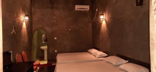 sypialnia z 2 łóżkami, lustrem i umywalką w obiekcie Djs Family Rest w mieście Kataragama