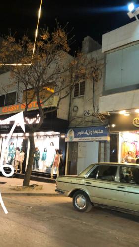 a car parked on the side of a street at night at Classy Hostel in Madaba